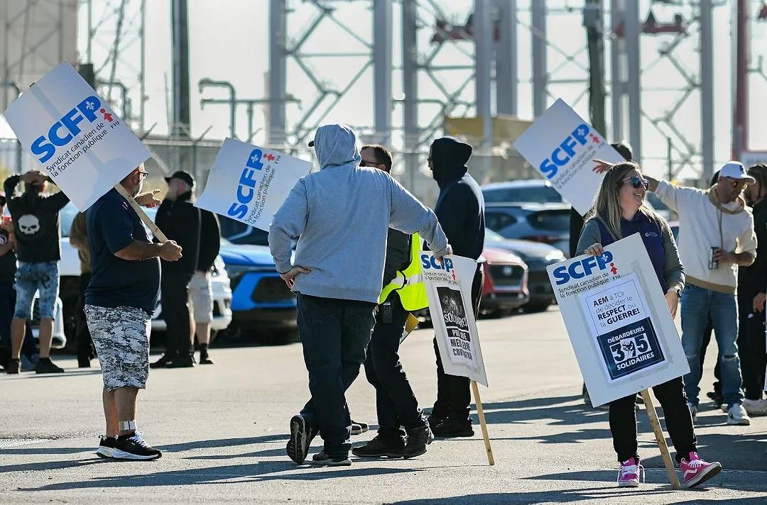 MULTIPLE PEOPLE IN HOODIES OUTDOORS HOLD SCFP PICKET SIGNS