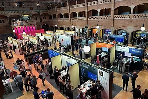 A GIANT HALL WITH GOTHIC BRICK ARCHES HOUSES DOZENS OF VENDOR BOOTHS