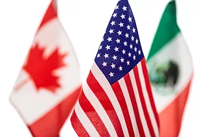 MINIATURE FLAGS OF US CANADA AND MEXICO ARE CLUSTERED TOGETHER, THE US ONE IN THE FOREGROUND