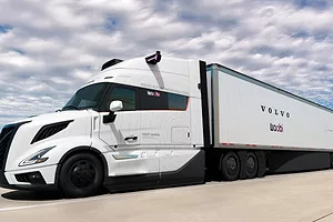 A sleek white semi-truck with black wheels, and "Volvo" and "Waabi" Printed across the side