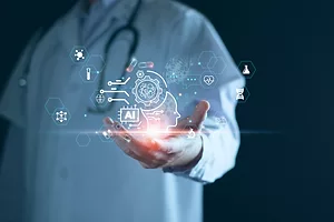 A man in a white lab coat with a stethoscope around his neck, with his hand out, holding a graphic rendering of a person's head, with a gear spoke and several icons expanding out from the head, with one reading "AI"