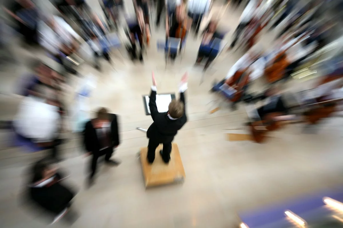 Bir orkestra şefinin orkestrayı yönettiğini gösteren stilize ve bulanık görüntü
