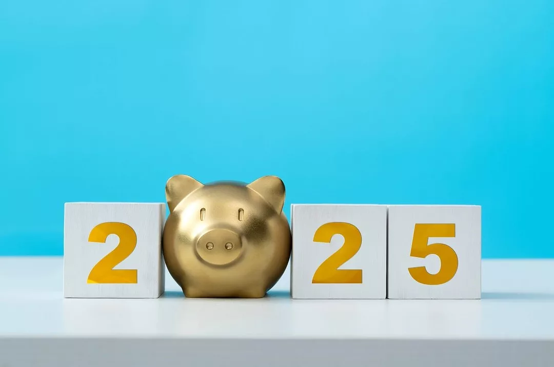 A GOLDEN, SMILING PIGGY BANK SITS AMONG THE NUMERALS 2025
