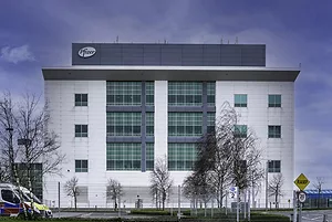 A LARGE GREY AND WHITE OFFICE BUILDING BEARS THE PFIZER LOGO