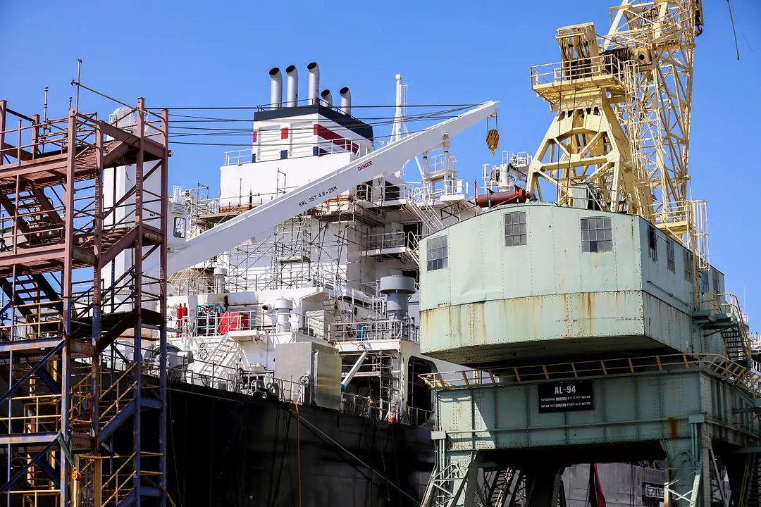 A SHIP UNDER CONSTRUCTION IS SURROUNDED BY SCAFFOLDING AND CRANES