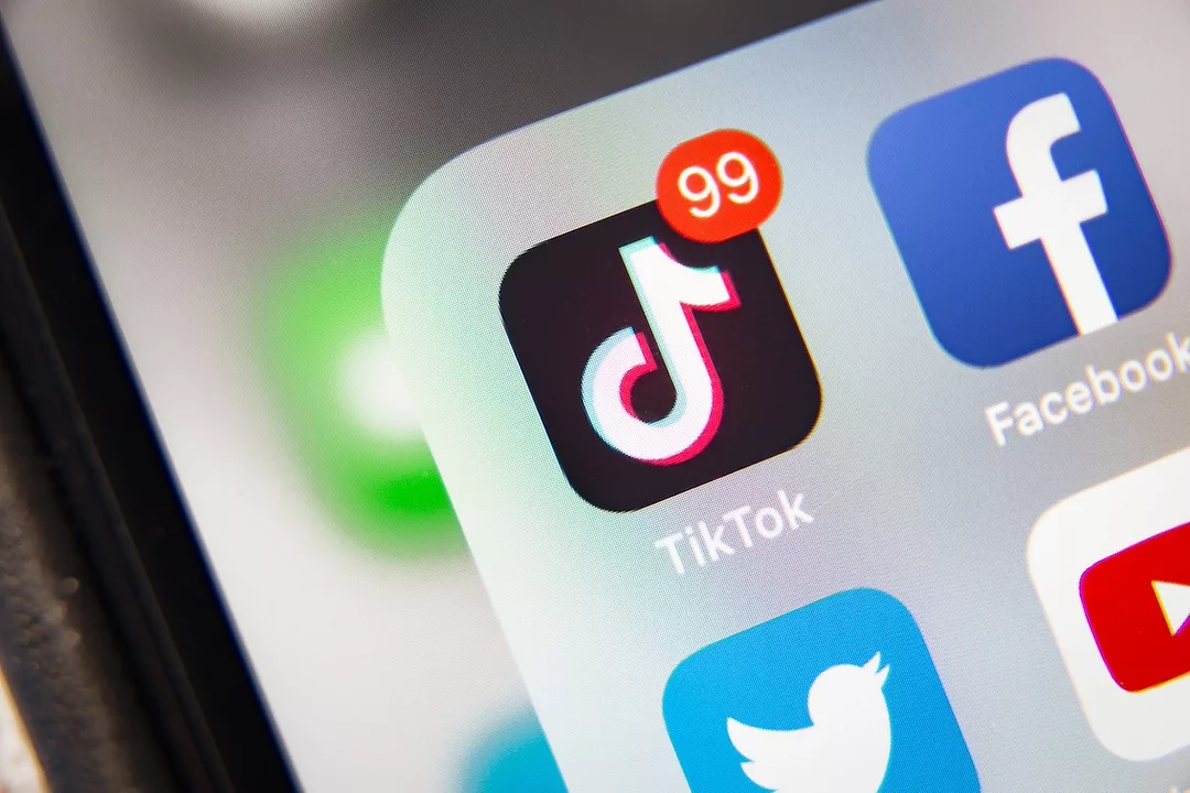 A black TikTok app icon on a smartphone screen