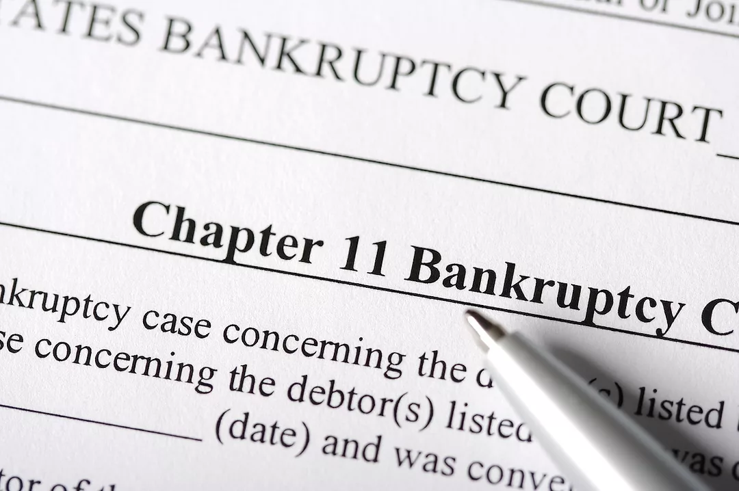A close-up of a document that reads "CHAPER 11 BANKRUPTCY" across the top