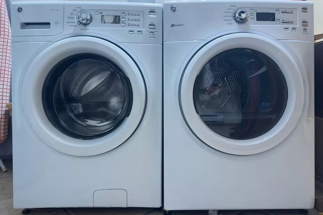 Two front loading white washing machines positioned next to each other
