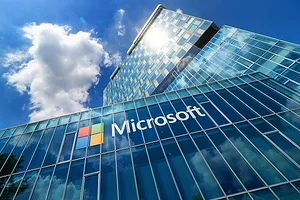 A GLEAMING OFFICE TOWER OF GLASS AND STEEL BEARS THE MICROSOFT LOGO