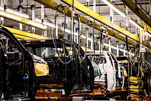 PARTIALLY COMPLETED AUTOMOBILES SIT ON A PRODUCTION LINE