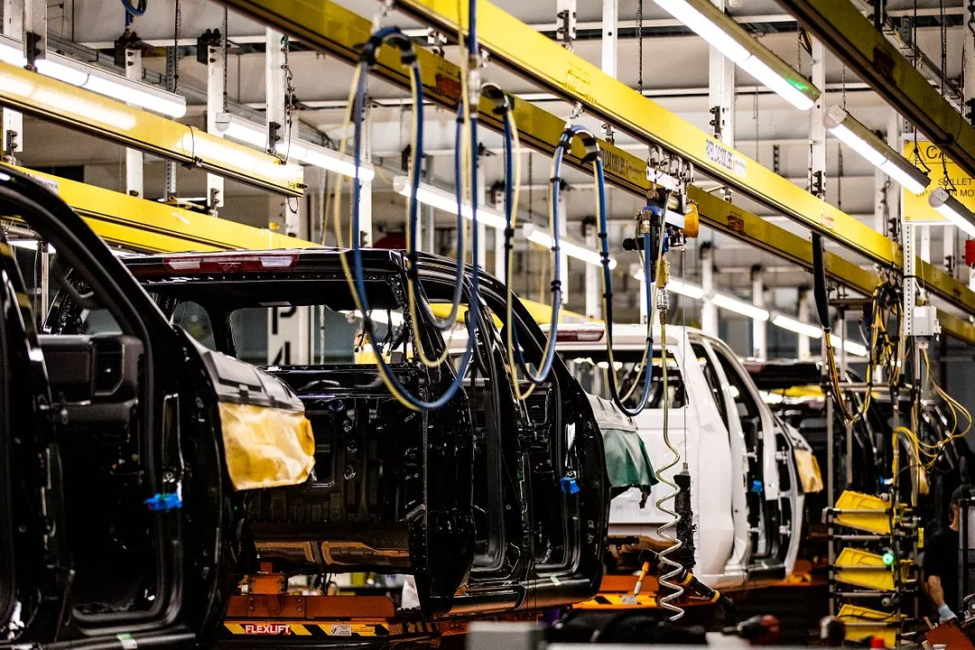 PARTIALLY COMPLETED AUTOMOBILES SIT ON A PRODUCTION LINE