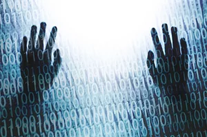 TWO HANDS ARE DIMLY SEEN THROUGH A SCREEN POPULATED WITH ZEROS AND ONES