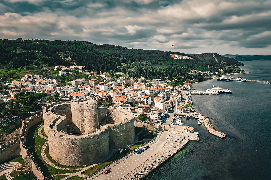 AN ANCIENT CASTLE LOOMS OVER A STRETCH OF SEA