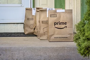 Four brown paper bags on a cement porch, with "PRIME" written across the bag at the front