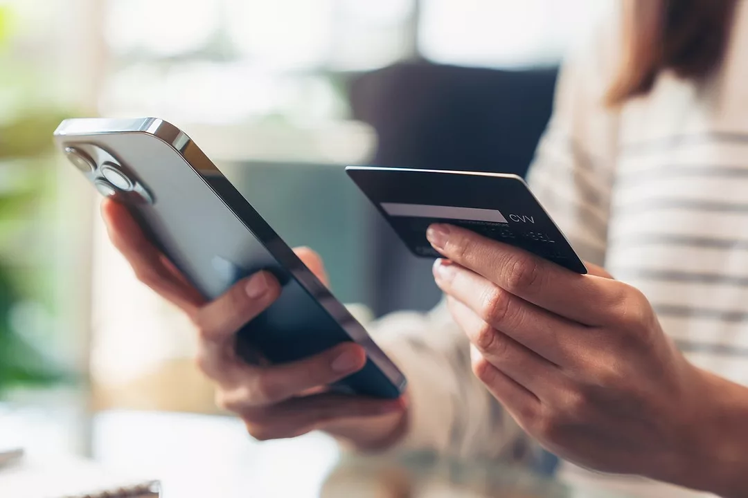 Woman hand holding credit cards and using smartphone for shopping online