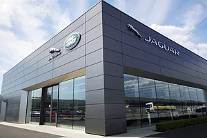A GLASS AND DARK GREY SIDING BUILDING SPORTS THE JAGUAR LOGO