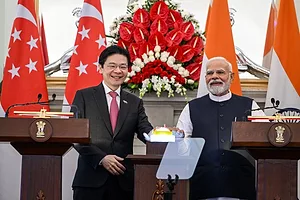 TWO MEN SURROUNDED BY FLAGS ON A PODIUM FACE OUTWARD, SMILING
