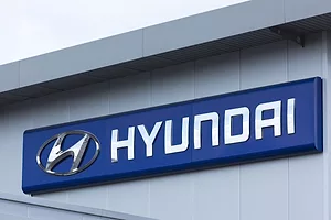 A blue sign across the top of a grey concrete building that reads "HYUNDAI" in white lettering