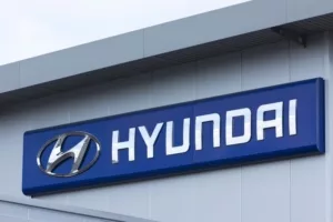 A blue sign across the top of a grey concrete building that reads "HYUNDAI" in white lettering