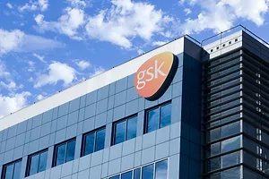 A GLASS AND STEEL OFFICE BUILDING BEARS THE ORANGE GSK LOGO