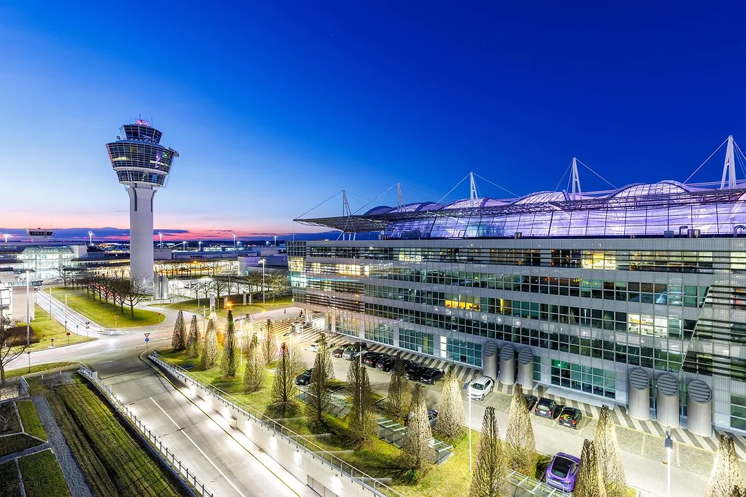 A GLEAMING AIRPORT SEEN AT DUSK, A CONTROL TOWER RISING ABOVE A TERMINAL