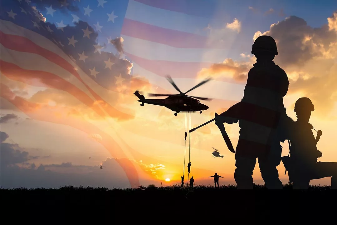 SOLDIERS HOLDING MACHINE GUNS ARE SILHOUTTED AGAINST THE SKY WHICH CONTAINS A HELICOPTER