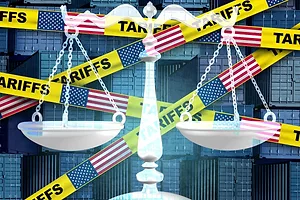 Yellow caution tape that reads "TARIFFS" alongside American flags crossed over stacks of blue shipping containers, with a old-fashioned scale in the foreground