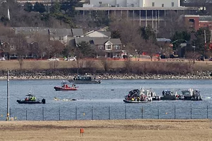 SMALL BOATS PLY A WATERWAY NEAR HOUSES