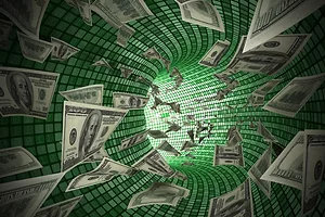 A GRAPHIC IMAGE SHOWS A CURVED, GLEAMING FUNNEL WITH DOLLAR BILLS BEING SUCKED DOWN IT