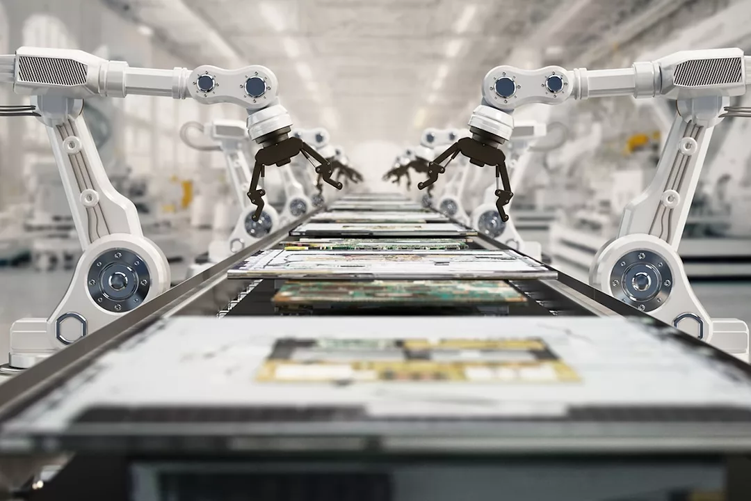 A row of white robotic arms arranged along a conveyor belt in a large white room