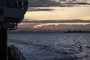 A city skyline at sunset seen from the ocean
