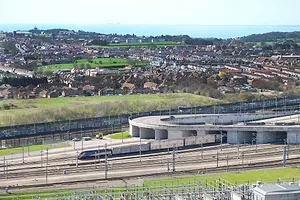 A TRAIN EMERGES FROM A MULTI-CHAMBERED TUNNEL SYSTEM INTO THE COUNTRYSIDEg
