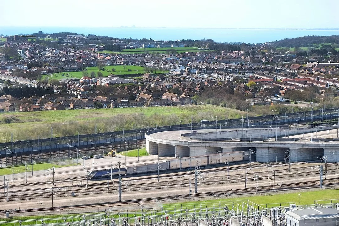 A TRAIN EMERGES FROM A MULTI-CHAMBERED TUNNEL SYSTEM INTO THE COUNTRYSIDEg