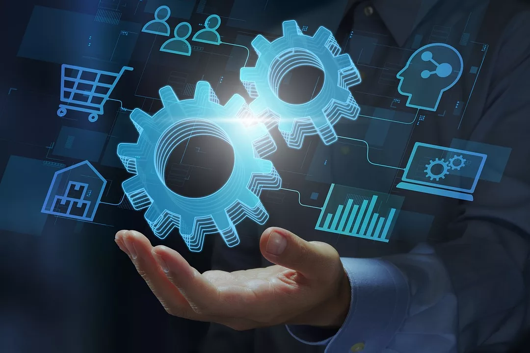 AN IMAGE WITH A HAND HOLDING FLOATING ICONS OF WHEEL COGS AND SOURCES OF DATA