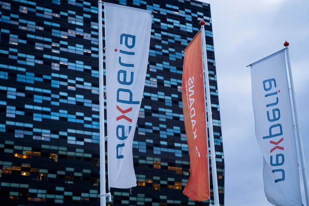 BANNERS BEARING THE NEXPERIA LOGO FLY OUTSIDE A MODERNIST OFFICE BLOCK