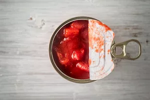 AN OPEN CAN OF TOMATOES, SEEN FROM ABOVE