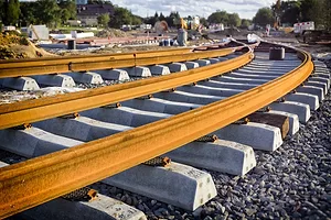 Orange railroad tracks curving around a turn