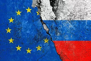 THE FLAGS OF RUSSIA AND THE EU PAINTED ON CONCRETE WITH A LARGE CRACK DOWN THE MIDDLE 