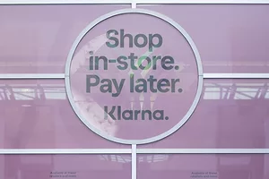 A window with a pink sign that reads "SHOP IN-STORE. PAY LATER. KLARNA."