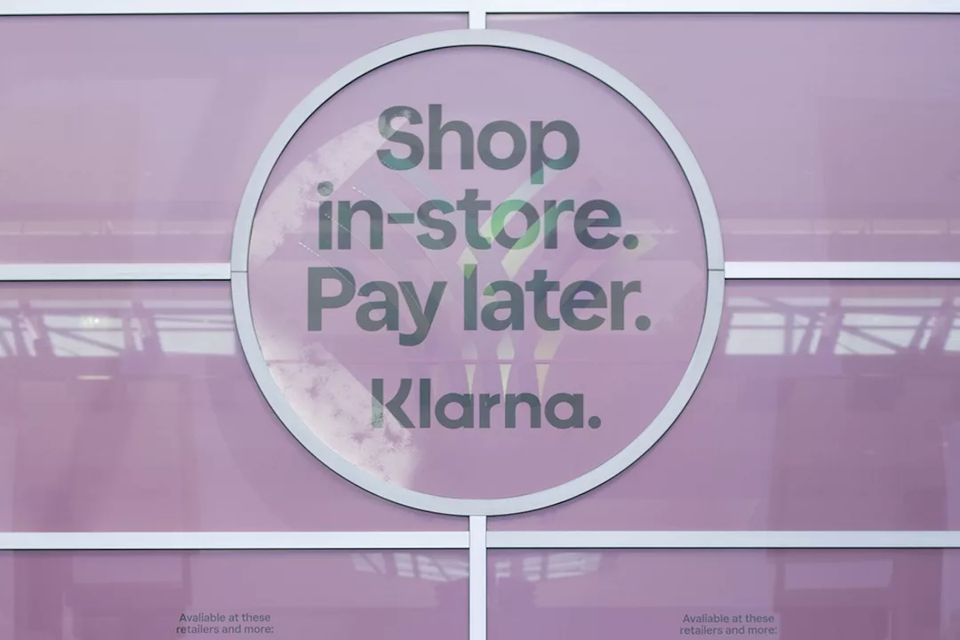 A window with a pink sign that reads "SHOP IN-STORE. PAY LATER. KLARNA."