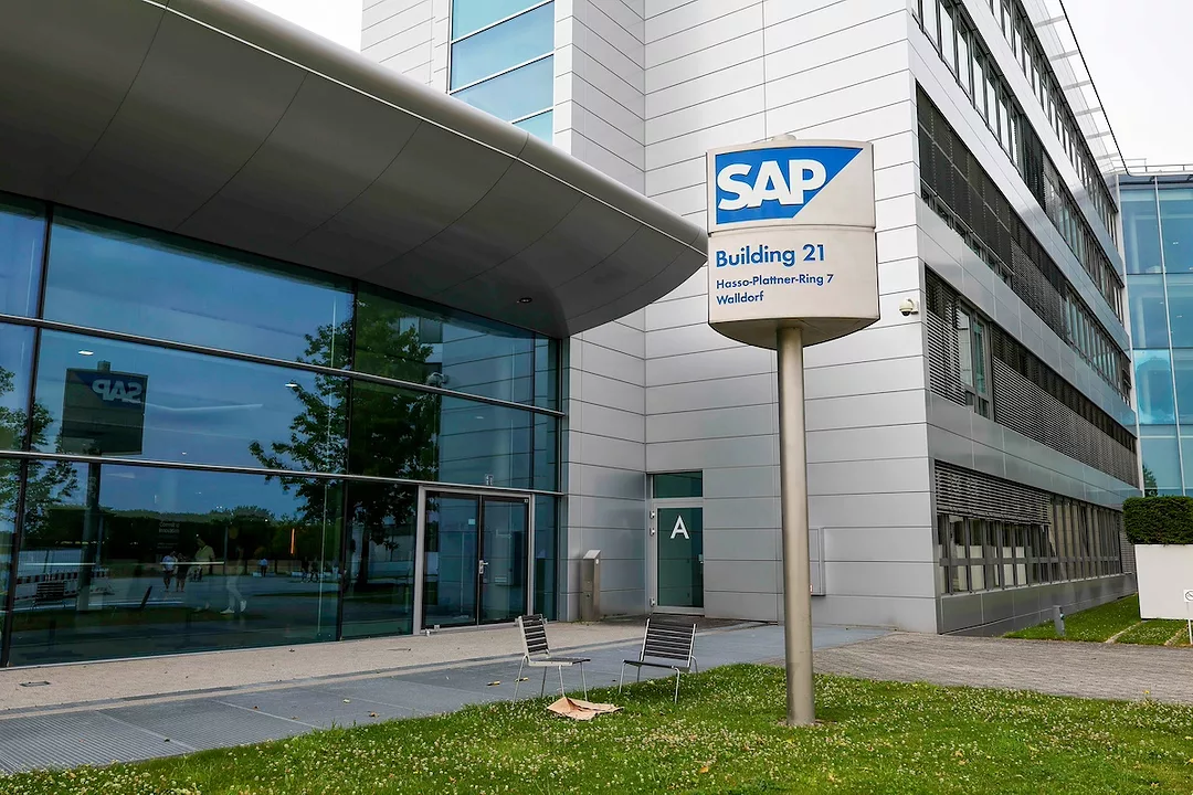 A white office building with a sign on a post that reads "SAP" against a blue background
