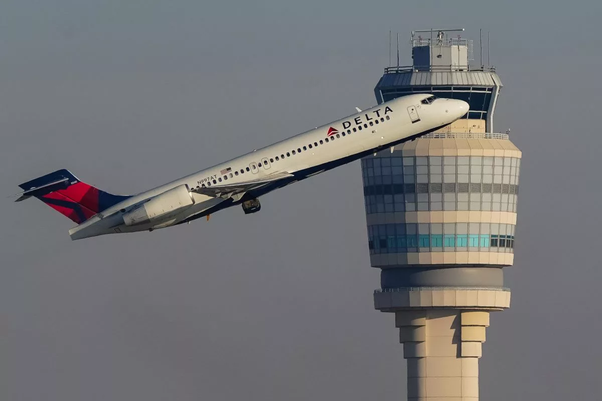 Bir havalimanı kontrol kulesinin önünde havalanmakta olan Delta Airlines uçağı