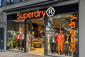 A SUPERDRY STORE FRONT CONTAINS COLORFUL CLOTHING