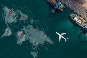 A visualization of a world map on the surface of a body of water next to a port, where two large container ships are docked