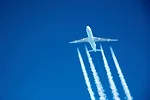 A PLANE FLYING HIGH IN A  BLUE SKY LEAVES VISIBLE WHITE TRAILSjpg