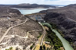A HUGE DAM HOLDS BACK WATER IN A DRY COUNTRYSIDE