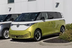 A GOLD AND WHITE BUS BEARS THE VW LOGO