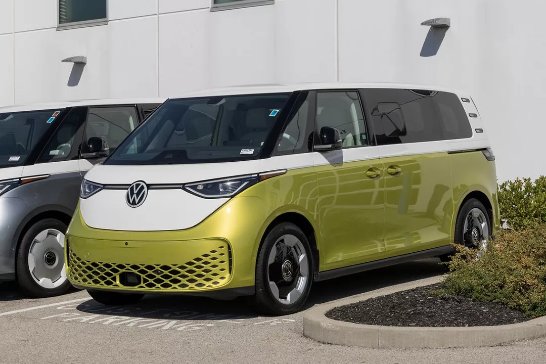 A GOLD AND WHITE BUS BEARS THE VW LOGO