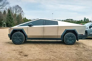 AN ODDLY SHAPED CAR WITH TINTED WINDOWS SEEN FROM THE SIDE