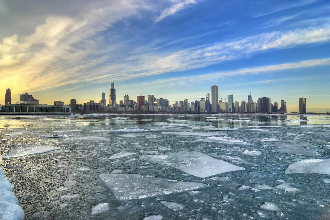 Frozen waters with the Chicago city skyline alone the distant horizon at sunrise